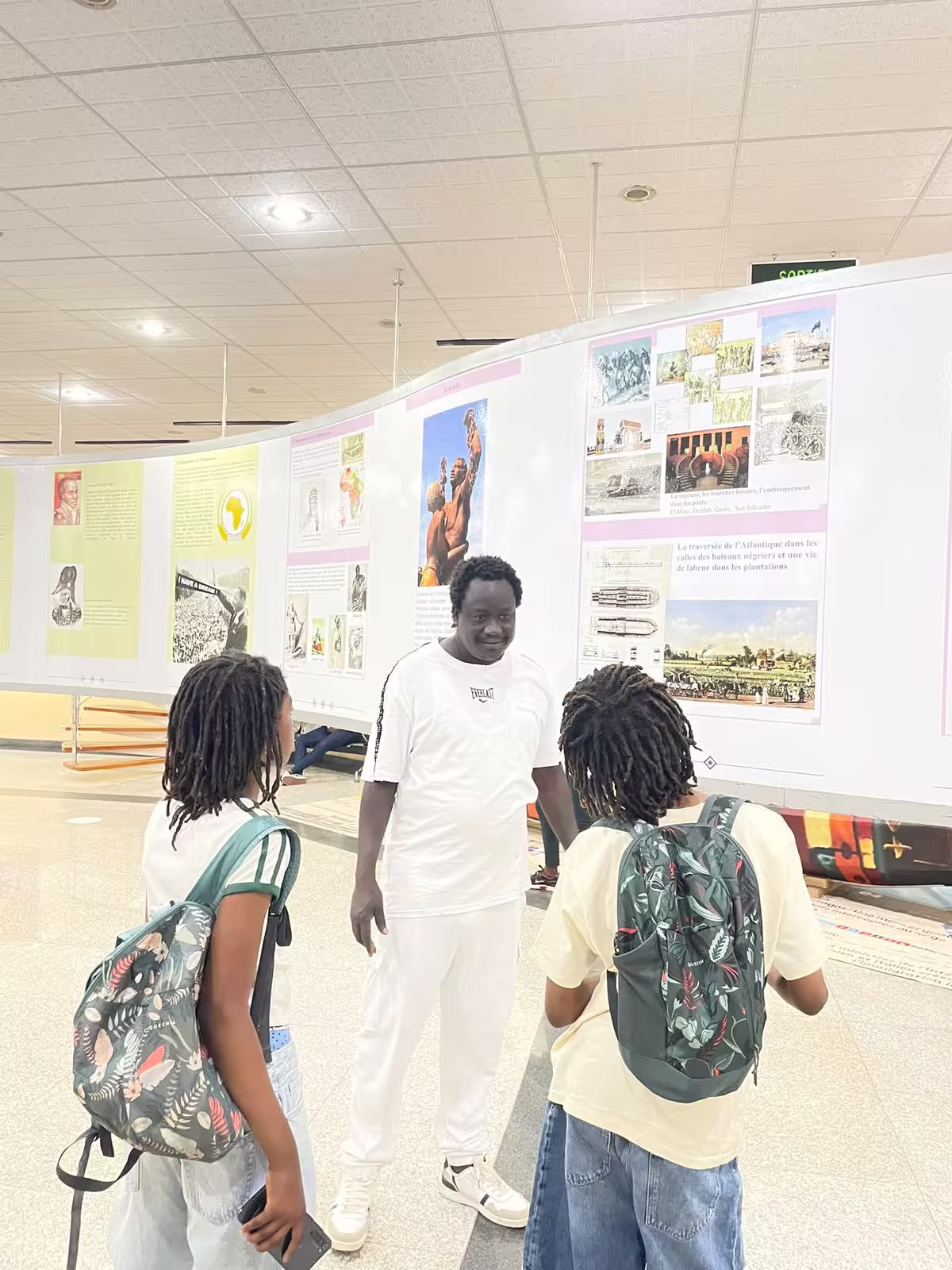 Diambar, guide indépendant, expliquant l'histoire de la traite atlantique à de jeunes visiteurs